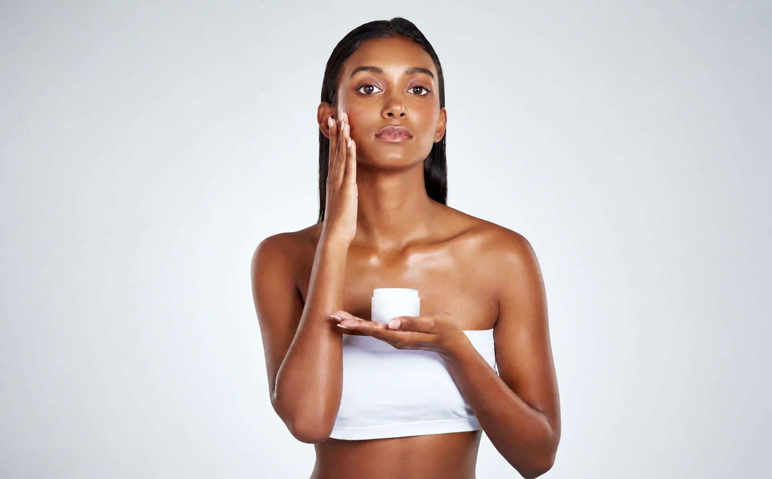 Woman applying facial moisturizer